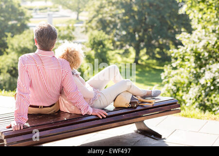 Di mezza età giovane relax su una panchina nel parco Foto Stock