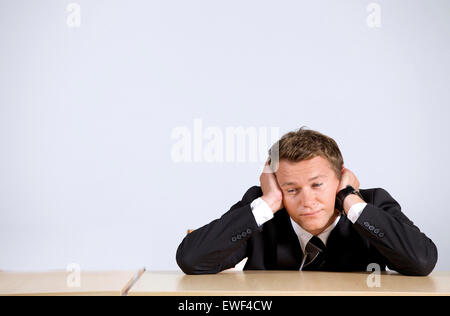 Imprenditore seduto con testa in mani in ufficio Foto Stock