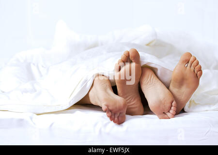 Close-up dei piedi di un giovane sul letto Foto Stock