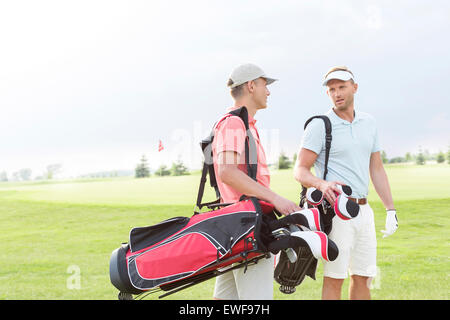Maschio di golfisti comunicare al campo da golf contro il cielo chiaro Foto Stock