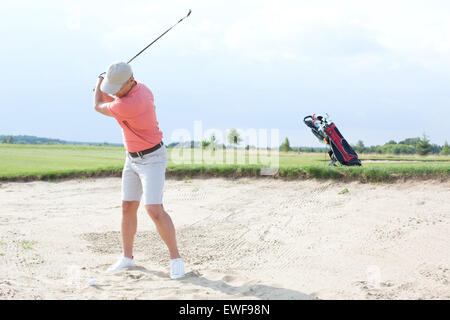 L'uomo swinging a campo da golf contro sky Foto Stock