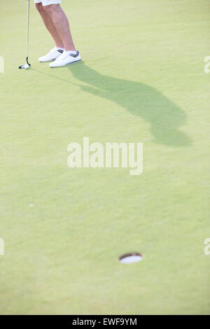 Sezione bassa di uomo di mezza età giocare a golf in corso Foto Stock