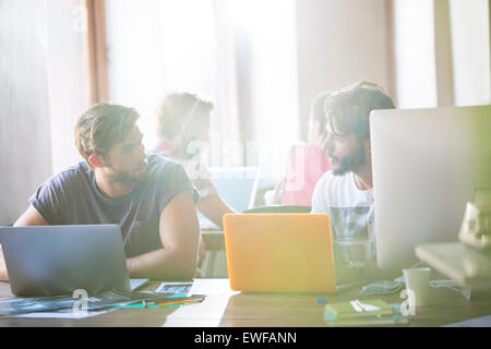 Gli imprenditori creativi lavora al notebook e parlando in ufficio Foto Stock