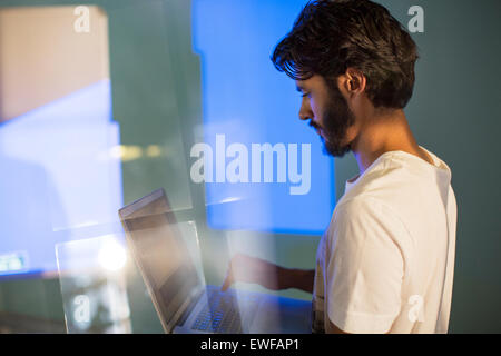 Casual uomo d affari con computer portatile preparazione presentazione audio visiva Foto Stock