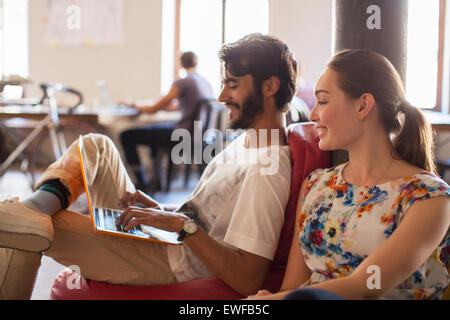 Casual la gente di affari con computer portatile in ufficio Foto Stock