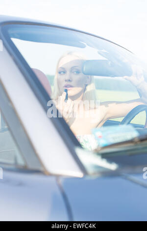 Donna rossetto nel convertibile sulla giornata di sole Foto Stock