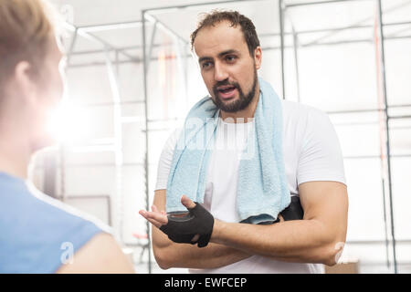 Uomo che parla di sesso maschile amico in palestra crossfit Foto Stock