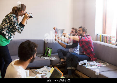 Gli imprenditori creativi con prove di posa per collaboratore con fotocamera istantanea Foto Stock