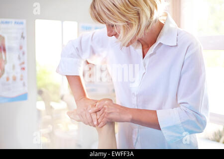 Fisioterapista massaggiare piede di un paziente Foto Stock