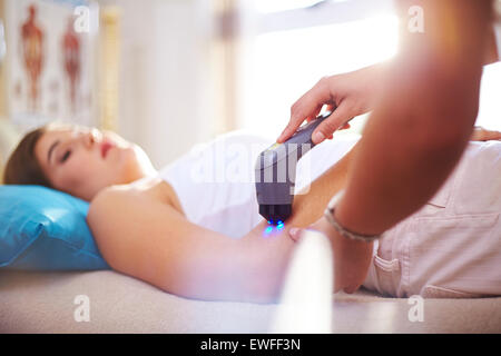 Terapista fisico usando la sonda ecografica sulla donna del braccio Foto Stock