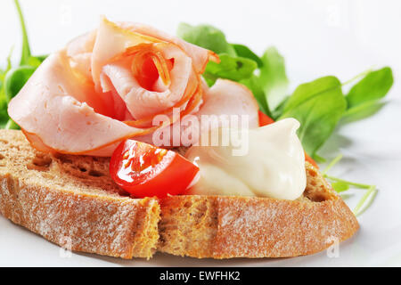 Fetta di pane con prosciutto e insalata verde Foto Stock