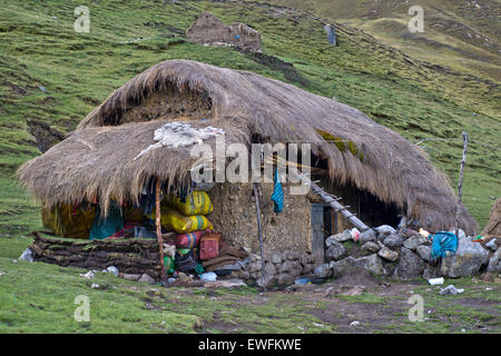 Tipico e tradizionale casa di abitazione, costruite di fango e pietre, con il tetto di paglia con erba, Cordillera Huayhuash mountain range, Ande Foto Stock