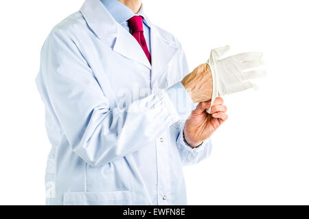 Maschio caucasico medico vestito in camice bianco, blu camicia e cravatta rossa è monouso da indossare dei guanti di protezione in lattice Foto Stock