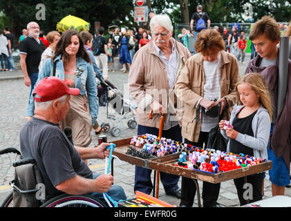 Parigi, Francia - 9 Agosto 2014: Disabilitato uomo anziano facendo piccoli colorati doni giocattolo vicino al Sacre Coeur basilica nel giorno di estate Foto Stock