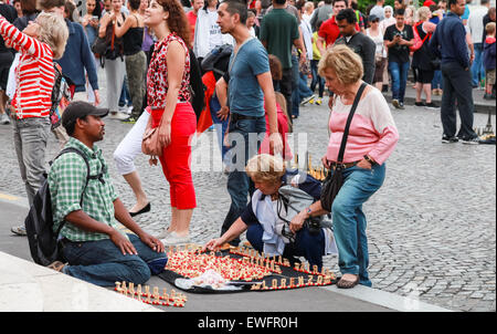 Parigi, Francia - 9 Agosto 2014: folla di turisti a piedi vicino al Sacre Coeur basilica nel giorno di estate, il venditore offre souvenir processo di produ Foto Stock