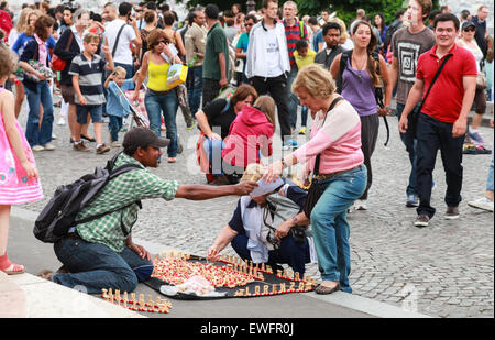 Parigi, Francia - 9 Agosto 2014: folla di turisti a piedi vicino al Sacre Coeur basilica nel giorno di estate, il venditore offre negozio di souvenir Foto Stock