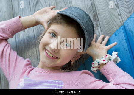 Ragazza rendendo il viso con le mani in alto Foto Stock