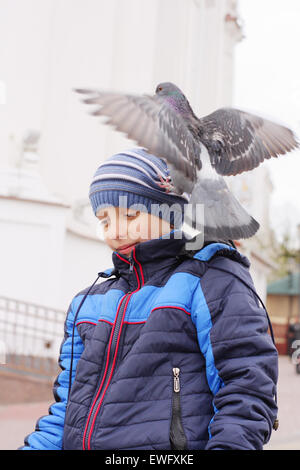 Ragazzo sorridente con colomba sulla testa Foto Stock