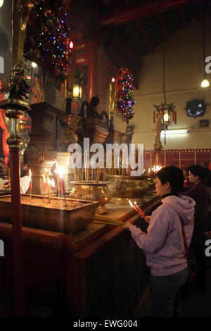 Hong Kong, Cina, buddisti devoti in Il Tempio di Man Mo Foto Stock