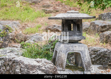 Un vecchio giapponese tradizionale lanterna di pietra in una casa Giapponese giardino. Foto Stock