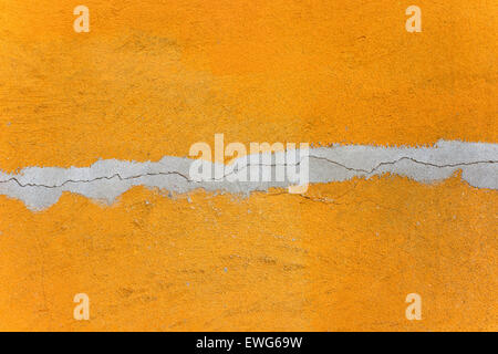 Arancione parete malta texture con crack grigio come sfondo Foto Stock