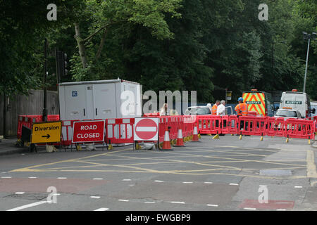 London, Regno Unito - 25 giu 2015 - operai e le chiusure della strada a Muswell Hill Road sulla giunzione con l'Archway road. L'area rimane chiusa al traffico a seguito di un incendio nelle prime ore del 23 Giu e conseguente allagamento dell'area. Credito: Finn Nocher/Alamy Live News Foto Stock