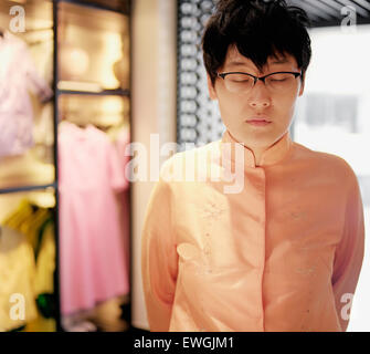 Una giovane donna di Taiwan i modelli i vestiti di progettista Shiatzy Chen a sua boutique di Taipei. Taipei, Taiwan. Foto Stock