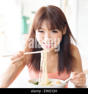 Ragazza asiatica mangiare tagliatelle al ristorante. Giovane donna vivere lo stile di vita. Foto Stock