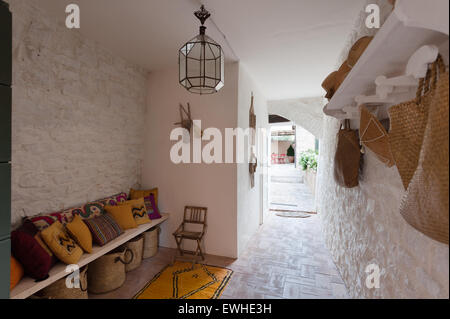 Coloratissimi cuscini etnici e tappeto marocchino in bianco lapidato corridoio con hat rack e lanterna in vetro Foto Stock