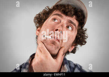 Pensando redneck abita su molti pensieri come fuma una sigaretta Foto Stock