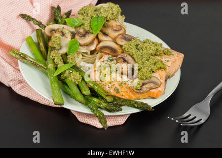 Delizioso salmone alla griglia con pesto cremosa salsa, gli asparagi e le linguine sul lato Foto Stock