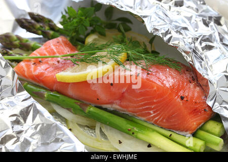 Salmone fresco con asparagi in carta stagnola, pronti per la cottura Foto Stock