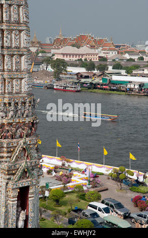 Una lunga coda imbarcazione turistica sul fiume Chao Phraya in Bangkok con il Wat Pho tempio in background Foto Stock