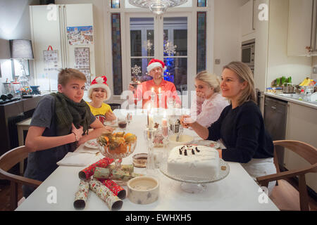 Una famiglia di cinque persone godetevi il pranzo di Natale Foto Stock