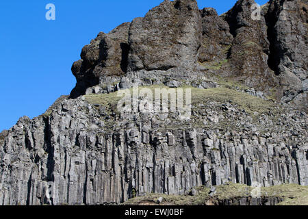 Basalto esagonale colonne vulcanica formazioni rocciose nelle scogliere vicino al mare Islanda Foto Stock