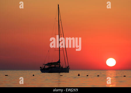 Tramonto su uno yacht per ancorare alla Baia di Ghajn Tuffieha A Malta Foto Stock