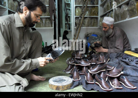 Peshawar. Il 27 giugno, 2015. La popolazione pakistana fare il tradizionale Peshawari Chappal in occasione di un seminario nel nord-ovest del Pakistan a Peshawar, 27 giugno 2015. Peshawari Chappal è una calzatura tradizionale del Pakistan, indossati in particolare dai pashtun nel Khyber Pakhtunkhwa regione del Pakistan. © Ahmad Sidique/Xinhua/Alamy Live News Foto Stock