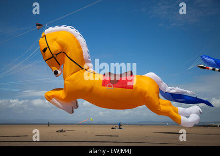 Arancione gonfiabile Cavallo kite galopping sulla spiaggia a Morecambe, Lancashire, UK Giugno, 2015. Inflatables Pegasus galopping cavallo Peter Lynn kite al Catch the Wind Kite Festival un evento annuale sul lungomare di Morecambe, quando per tutta la giornata i cieli sono pieni delle forme, colori e creazioni più spettacolari degli animali. Foto Stock