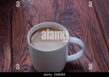 Su una tavola di legno con il bianco tazza di caffè con latte Foto Stock