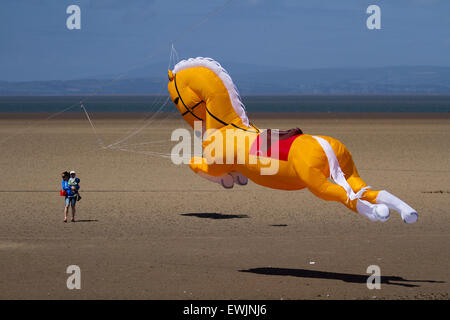 Arancione gonfiabile Cavallo kite galopping sulla spiaggia a Morecambe, Lancashire, UK Giugno, 2015. Inflatables Pegasus galopping cavallo Peter Lynn kite al Catch the Wind Kite Festival un evento annuale sul lungomare di Morecambe, quando per tutta la giornata i cieli sono pieni delle forme, colori e creazioni più spettacolari degli animali. Foto Stock
