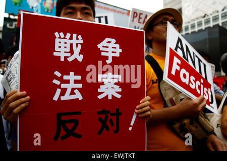 I membri di studenti azione di emergenza per la democrazia liberale-s (SEALDs) chiamata per la protezione del pacifista di articolo 9 della Costituzione giapponese in Shibuya quartiere dello shopping a giugno 27, 2015, Tokyo, Giappone. Circa mille persone hanno manifestato davanti alla famosa intersezione al di fuori della stazione di Shibuya contro il Primo Ministro Abe reinterpretazione dell articolo 9 che consentirebbe la nazione, le truppe per la lotta all'estero. © Rodrigo Reyes Marin/AFLO/Alamy Live News Foto Stock