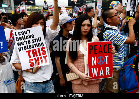 I membri di studenti azione di emergenza per la democrazia liberale-s (SEALDs) chiamata per la protezione del pacifista di articolo 9 della Costituzione giapponese in Shibuya quartiere dello shopping a giugno 27, 2015, Tokyo, Giappone. Circa mille persone hanno manifestato davanti alla famosa intersezione al di fuori della stazione di Shibuya contro il Primo Ministro Abe reinterpretazione dell articolo 9 che consentirebbe la nazione, le truppe per la lotta all'estero. © Rodrigo Reyes Marin/AFLO/Alamy Live News Foto Stock