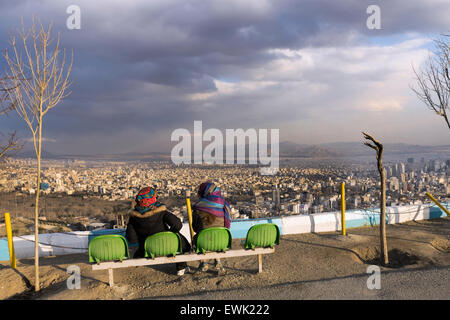 Due donne a guardare il tramonto su Teheran dal Monte Tochal, Iran Foto Stock