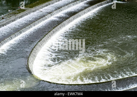 BATH CITY le curve di sbarramento e il gorgogliamento di acqua sul fiume Avon sotto il Pulteney Bridge Foto Stock