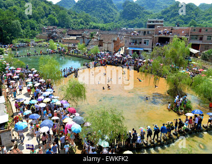 Yongzhou, provincia cinese di Hunan. Il 28 giugno, 2015. Persone pescare nel fango durante un festival locale celebra il ricongiungimento dei coniugi nel Jiangyong County, centrale provincia cinese di Hunan, 28 giugno 2015. Nei tempi antichi, locale gli uomini hanno lavorato e vissuto nella risaia lontano dalla loro casa fino a fine primavera arando. Essi lavato via il fango sui loro piedi e il ricongiungimento con le loro mogli. Per celebrare la reunion, persone locali impostare il festival. © Huang Hai/Xinhua/Alamy Live News Foto Stock