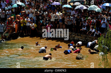 Yongzhou, provincia cinese di Hunan. Il 28 giugno, 2015. Persone pescare nel fango durante un festival locale celebra il ricongiungimento dei coniugi nel Jiangyong County, centrale provincia cinese di Hunan, 28 giugno 2015. Nei tempi antichi, locale gli uomini hanno lavorato e vissuto nella risaia lontano dalla loro casa fino a fine primavera arando. Essi lavato via il fango sui loro piedi e il ricongiungimento con le loro mogli. Per celebrare la reunion, persone locali impostare il festival. © Huang Hai/Xinhua/Alamy Live News Foto Stock