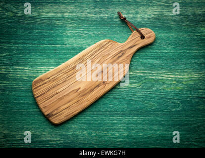 Composizione con olive wood board sulla parte superiore del tavolo in legno di quercia, rustico sfondo. Vista dall'alto. Foto Stock