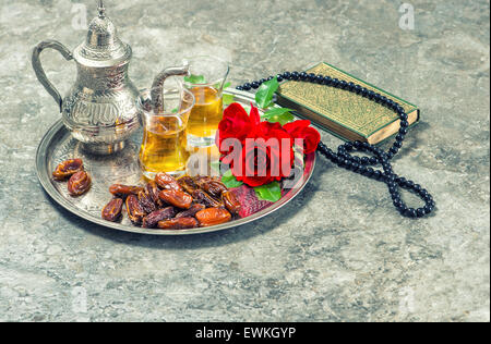 Tè, Red Rose fiore, date, libro sacro Corano e di Rosario. Festività islamiche decorazione. Il Ramadan kareem. Eid Mubarak. Oriental hosp Foto Stock