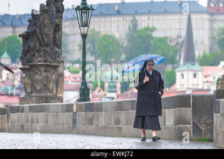 Nun da sola città EUROPA, all'inizio. La luce del mattino una suora passeggiate attraverso il Ponte Carlo a Praga, Repubblica Ceca. Foto Stock