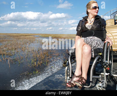 Una donna su una sedia a rotelle su un idroscivolante accessibile in Everglades Foto Stock